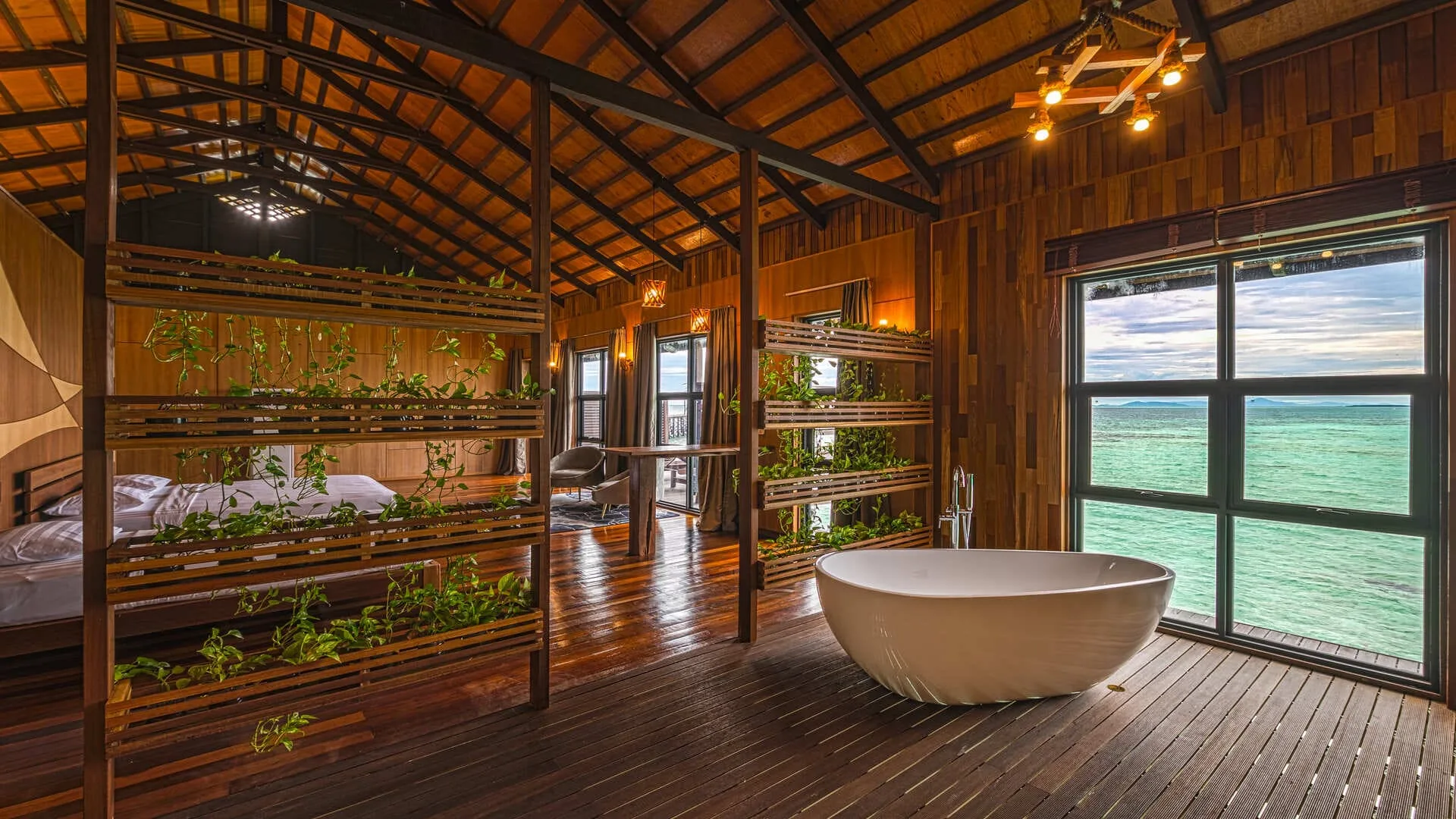 Romantic overwater bungalow exterior at Pearl Island Resort with sea views at sunset.